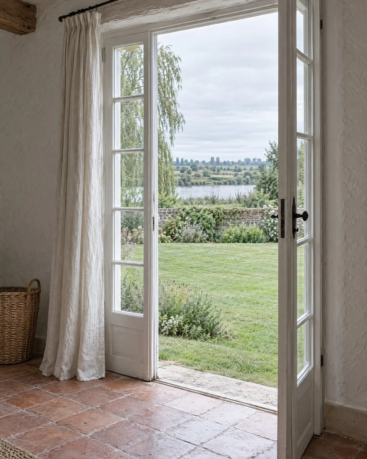 La porte-fenêtre de la chambre Croissant ouverte de plain-pied sur la pelouse et le potager