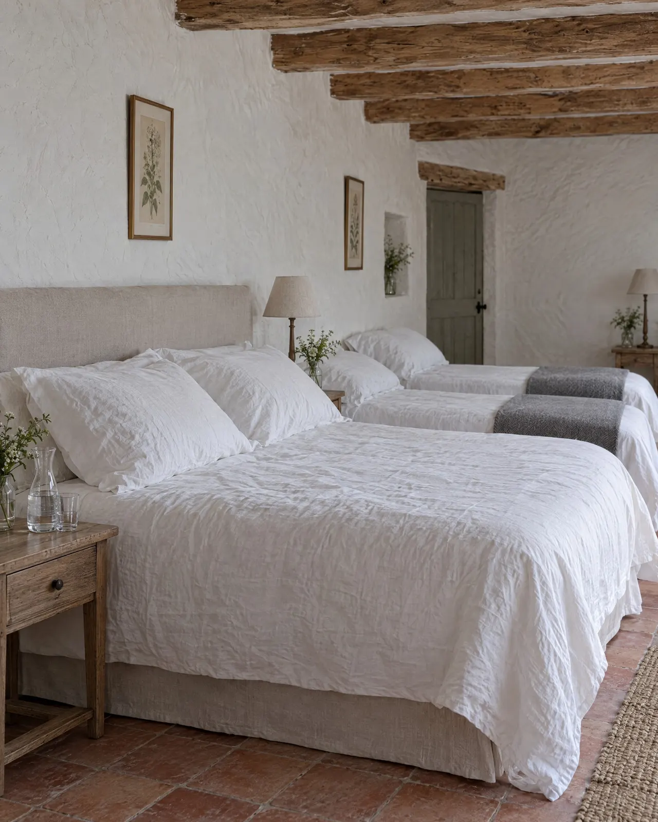Le lit de 160 de la chambre Croissant, drap blanc et mur chaulé derrière la tête de lit